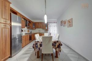 una cucina con tavolo e frigorifero in acciaio inox di Cosy 3BR home Apt with private balcony in B'Bugia a Birżebbuġa
