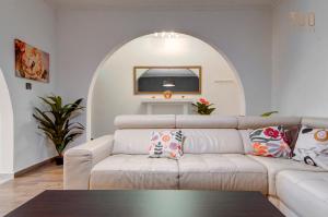 un soggiorno con divano bianco e arco di Cosy 3BR home Apt with private balcony in B'Bugia a Birżebbuġa