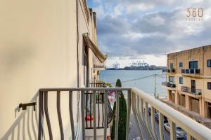 balcone di un edificio con vista sull'acqua di Cosy 3BR home Apt with private balcony in B'Bugia a Birżebbuġa Altre 37 foto