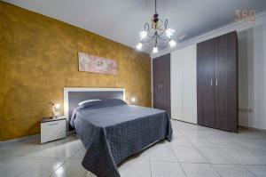 una camera da letto con un letto e una parete gialla di Cosy 3BR home Apt with private balcony in B'Bugia a Birżebbuġa