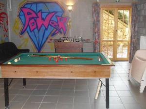una mesa de billar en una habitación con graffiti en la pared en Le Gibier - Vakantiewoning, en Bomal