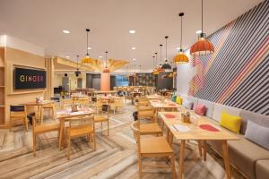 a restaurant with tables and chairs and a couch at Ginger Agartala in Agartala