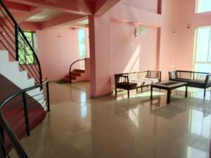 a room with chairs and tables in a building at Dev anand Villa in Mahabaleshwar