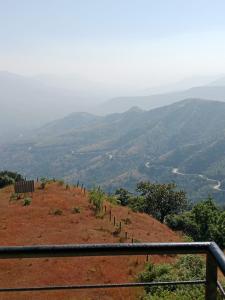 a view of a hill with a fence on it at Dev anand Villa in Mahabaleshwar
