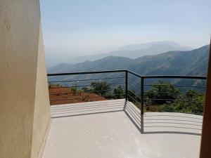 a balcony with a view of the mountains at Dev anand Villa in Mahabaleshwar +10 photos