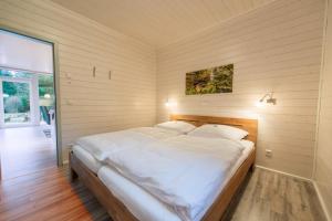 a bedroom with a large bed with white sheets at bis 4 Personen mit Infrarotsauna F2H9 in Ruhla