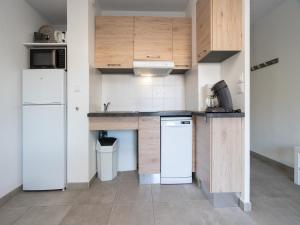 a kitchen with white appliances and wooden cabinets at La Dune N 12 - Villa 3P6 in Valras-Plage