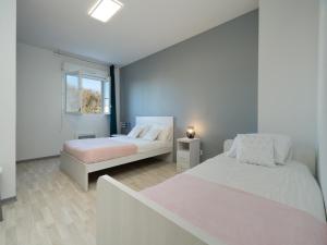 a bedroom with two beds and a window at La Dune N 12 - Villa 3P6 in Valras-Plage +12 photos