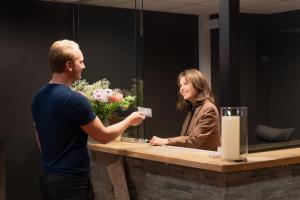 トロムソにあるEnter Skansen Hotelの受付カウンターに立つ男女