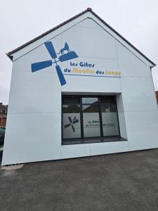 a white building with a window in the front at Les Gîtes du Moulin des Loups studios 3 et 6 in Saint-Amand-les-Eaux