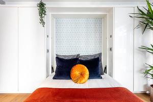 Dormitorio con cama con almohada naranja en Idyllic Covent Garden Flat, en Londres