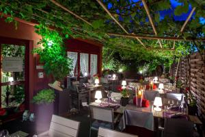 um restaurante com mesas, cadeiras e plantas em Auberge De Maison Rouge em Vétraz-Monthoux