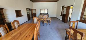 a dining room with a wooden table and chairs at Leeu Gamka Hotel in Leeu-Gamka