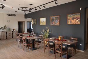 a dining room with wooden tables and chairs at Jász Vendégház in Jászladány