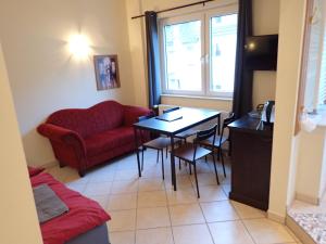 a living room with a red couch and a table at Cologne Apartments, direkt am Dom Zentrum 3 Zimmer Studio 46 qm in Cologne