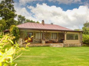 a small house with a red roof on a yard at Watersmeet cottages in Dullstroom