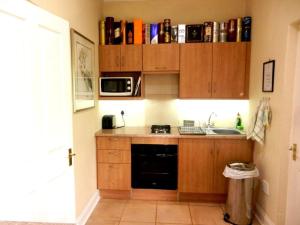 a small kitchen with wooden cabinets and a sink at Watersmeet cottages in Dullstroom