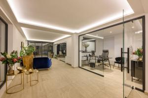 an office lobby with a blue chair and tables at Cens Silver Suites in Ioannina