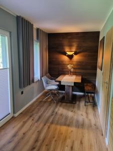 a dining room with a wooden wall and a table and chairs at Bungalow Uhu mit Aussensauna in Lage +7 photos