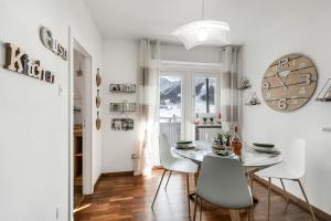 a dining room with a white table and chairs at Studio Blue Petit - Happy Rentals in Sestriere