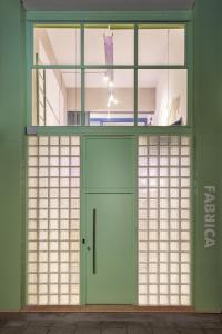a green door in a room with windows at Fabrica PlayLoft in the City Center by BiNoBi! in Thessaloniki +45 photos