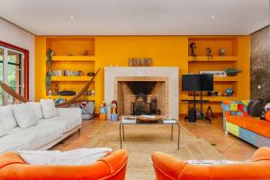 ein Wohnzimmer mit gelben Wänden und einem Kamin in der Unterkunft Villa Rancho do Sol by Trip2Portugal in Santo Estêvão
