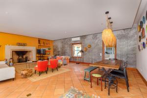 ein Wohnzimmer mit einem Tisch und roten Stühlen in der Unterkunft Villa Rancho do Sol by Trip2Portugal in Santo Estêvão