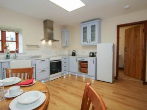 a kitchen with a table and a white refrigerator at Walton Maisonette in Craven Arms
