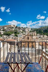 eine Holzbank auf einer Stadt in der Unterkunft Casa Teresa con vista in Modica