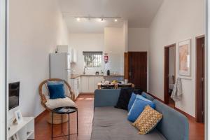 a living room with a blue couch and a kitchen at Casa do Profeta by An Island Apart in Porto Santo
