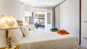 Un dormitorio con una cama con una lámpara y una ventana. en Residenza Khaddiuggia, en Pantelleria 77 fotos más