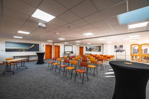 a conference room with chairs and a table and a podium at Hotel Base Camp Lodge - Albertville in Albertville +157 photos