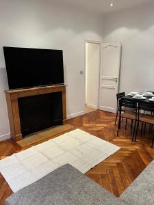 a living room with a fireplace with a tv on the wall at Magnifique appartement 2 chambres Paris 16e Trocadéro Tour Eiffel in Paris