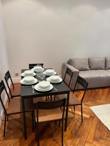 a black dining room table with chairs and a couch at Magnifique appartement 2 chambres Paris 16e Trocadéro Tour Eiffel in Paris +42 photos