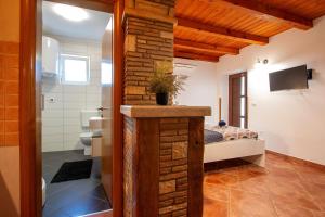 a bathroom with a toilet and a bed in a room at Studio Mateo in Rovinjsko Selo