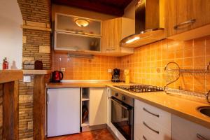 a kitchen with white cabinets and orange tile at Studio Mateo in Rovinjsko Selo