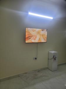 a painting hanging on a wall next to a refrigerator at Crystaljen Apartment in Mtwapa +5 photos