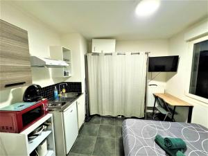 a small kitchen with a bed in a room at Studio Confortable Proche Gare in Melun