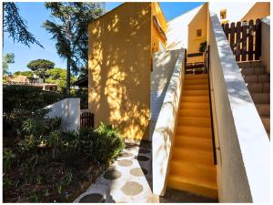 una scala che porta a una casa gialla di Le Parfum d'élégance a Cap d'Agde
