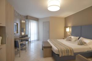 a hotel room with a bed and a dining room at Alma di Alghero Hotel in Alghero