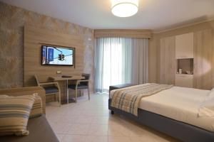 a hotel room with a bed and a dining table at Alma di Alghero Hotel in Alghero