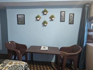 a room with a table and chairs and plants on the wall at The Heavens in Almora
