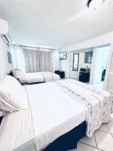 a large bedroom with two beds and a tv at Mystical Studios Double in Ocho Rios