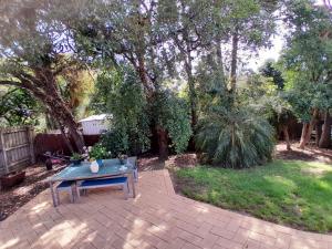 a patio with a table in a yard with trees at Ocean Oasis Rosebud in Rosebud