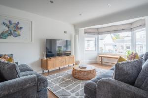 Una sala de estar con dos sofás y un televisor. en Hoheck, en Pwllheli