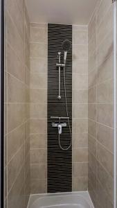 a bathroom with a shower with a bath tub at L Anatole Hyper centre Calme sur cour in Pézenas