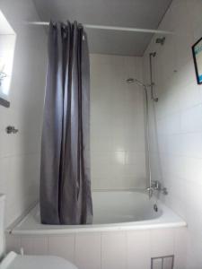 a bath tub with a shower curtain in a bathroom at Carcavelos Beach&Bike House (view, parking, wi-fi) in Carcavelos +16 photos