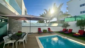 a pool with chairs and a table and an umbrella at Lua - Private Pool - 8 Guests - Albufeira in Albufeira