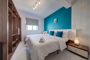 a bedroom with a large bed with blue walls at Stunning 2BR home with spacious living in Ta'Xbiex by 360 Estates in Taʼ Xbiex