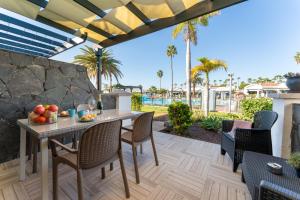 jadalnia na świeżym powietrzu ze stołem i krzesłami w obiekcie Luxury Poolside Holiday Home w mieście Maspalomas